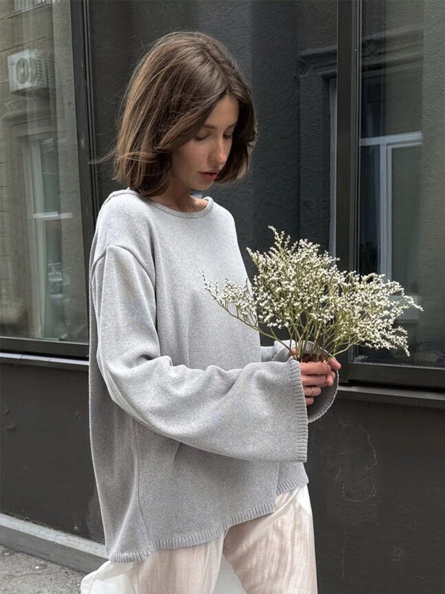 Woman wearing light gray knit sweater front view outdoors