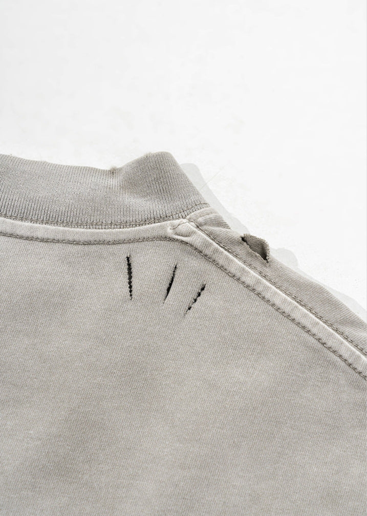 Stitch accents near the collar on back of light grey t-shirt.