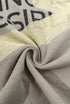 Twisted fabric close-up of light grey tee showing print texture.