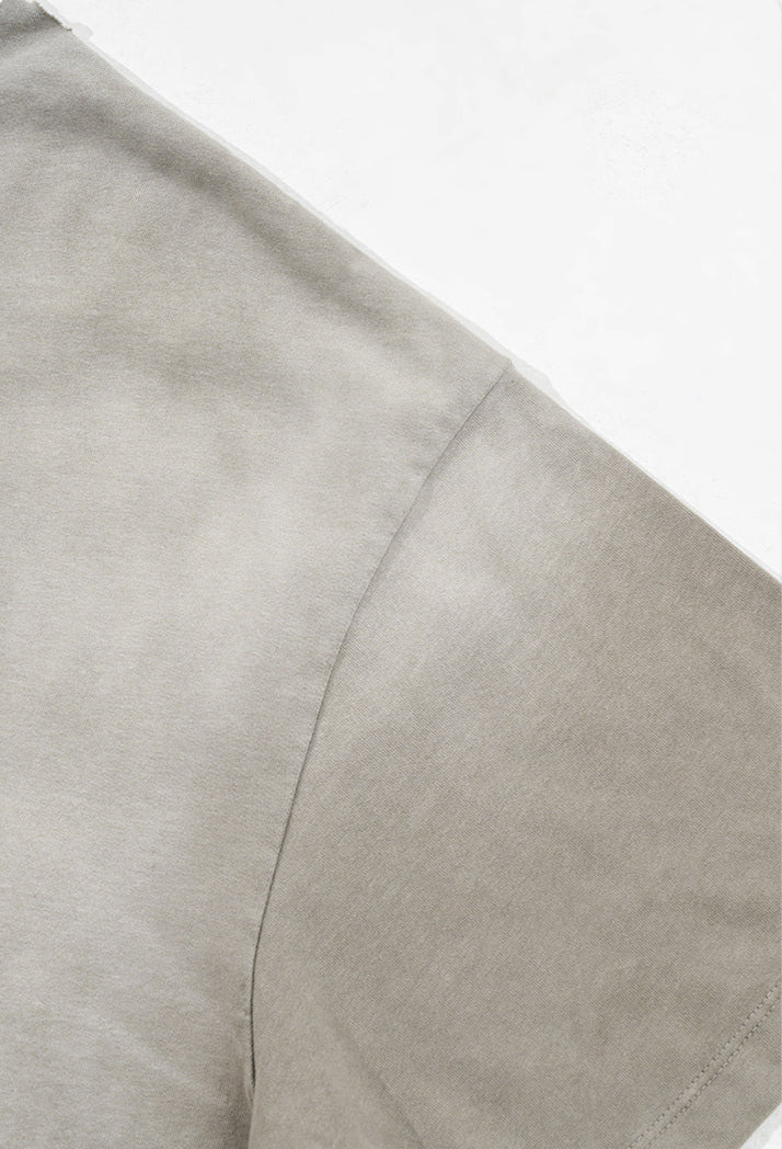 Light grey t-shirt shoulder seam and sleeve construction close-up.