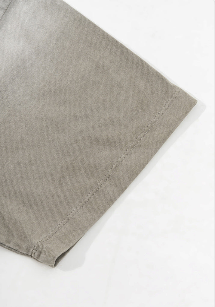 Hem and sleeve edge stitching detail on light grey tee.