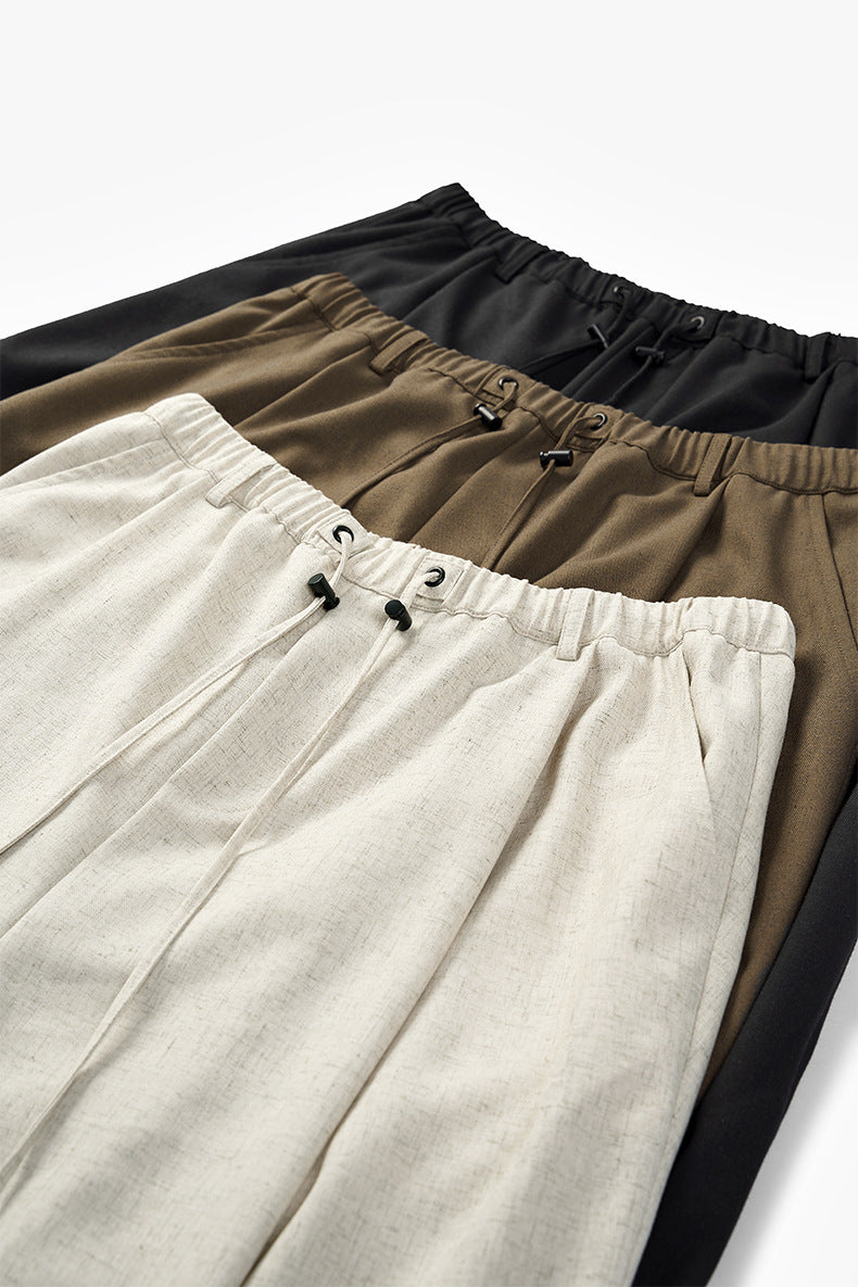 Linen wide-leg trousers in beige, khaki, and black stacked together