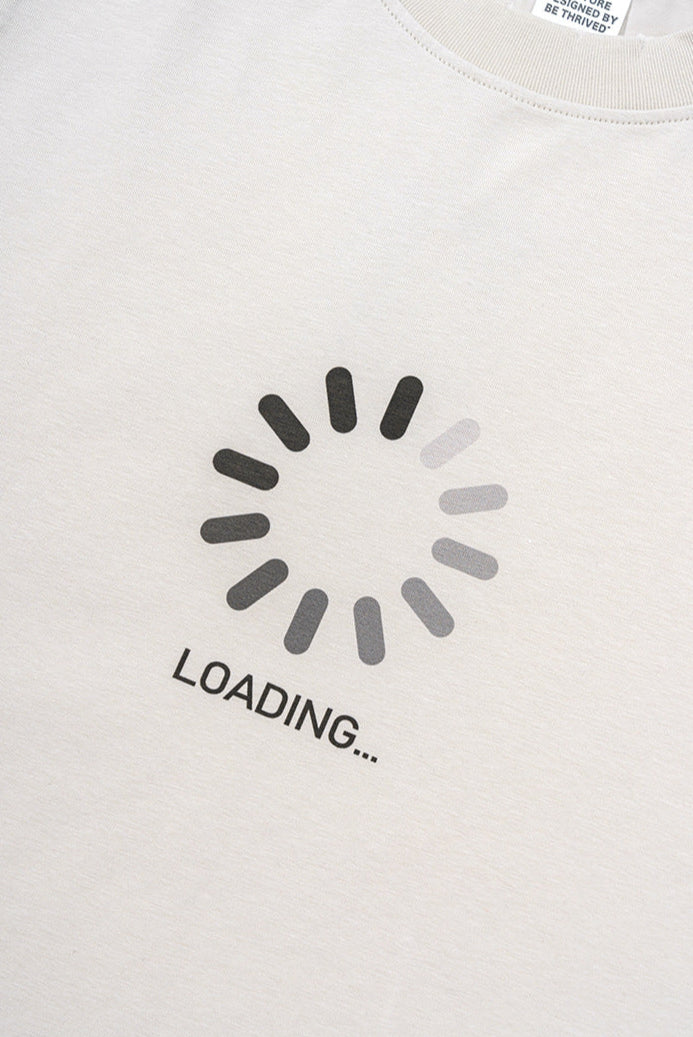 Close-up of spinner and “LOADING...” print on cream tee