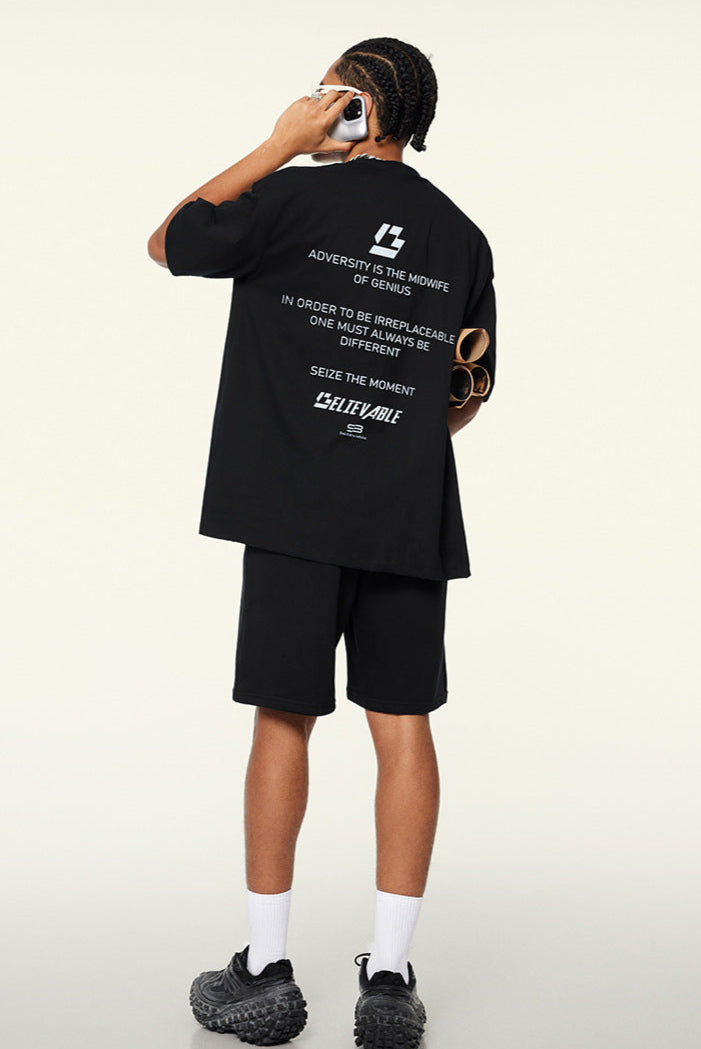 Back view of black tee showing motivational text and branding.
