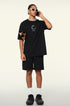 Man on phone wearing black loading tee and sunglasses.