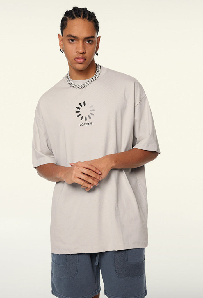 Men wearing cream t-shirt with “LOADING...” spinner graphic on front.