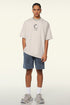 Man in cream loading tee standing with casual posture.