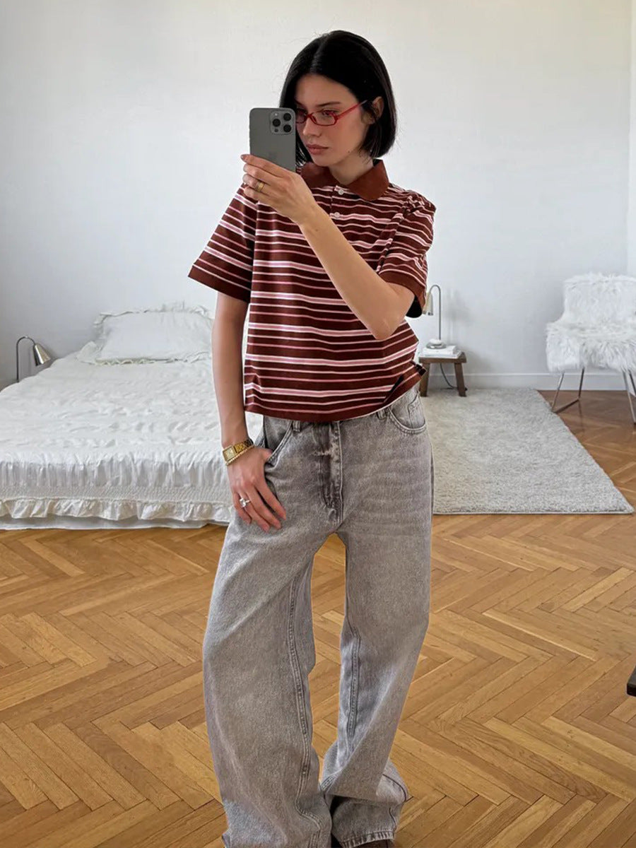 Model takes mirror selfie wearing brown striped polo shirt and wide-leg gray jeans.