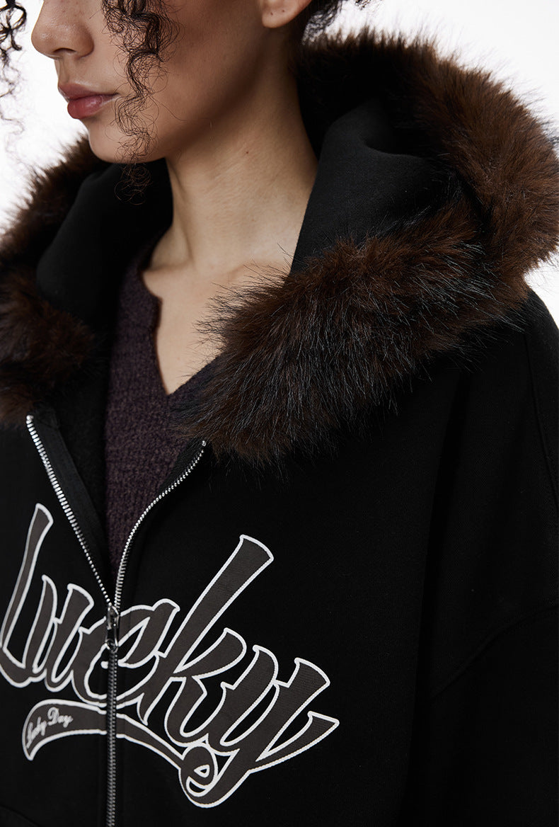 Side chest close-up of black jacket with fur trim and logo.