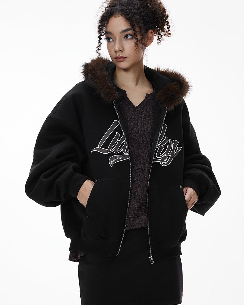 Female model in black jacket, hands in pockets, front view.