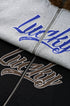 Split detail—black logo embroidery and gray blue “Lucky” print.