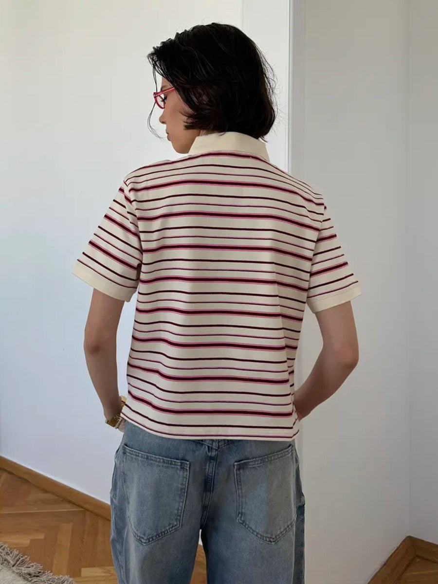 Back view of model in cream and maroon striped polo shirt and loose blue jeans.