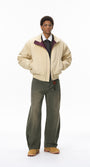 Model in beige men bomber jacket with green pants, relaxed pose