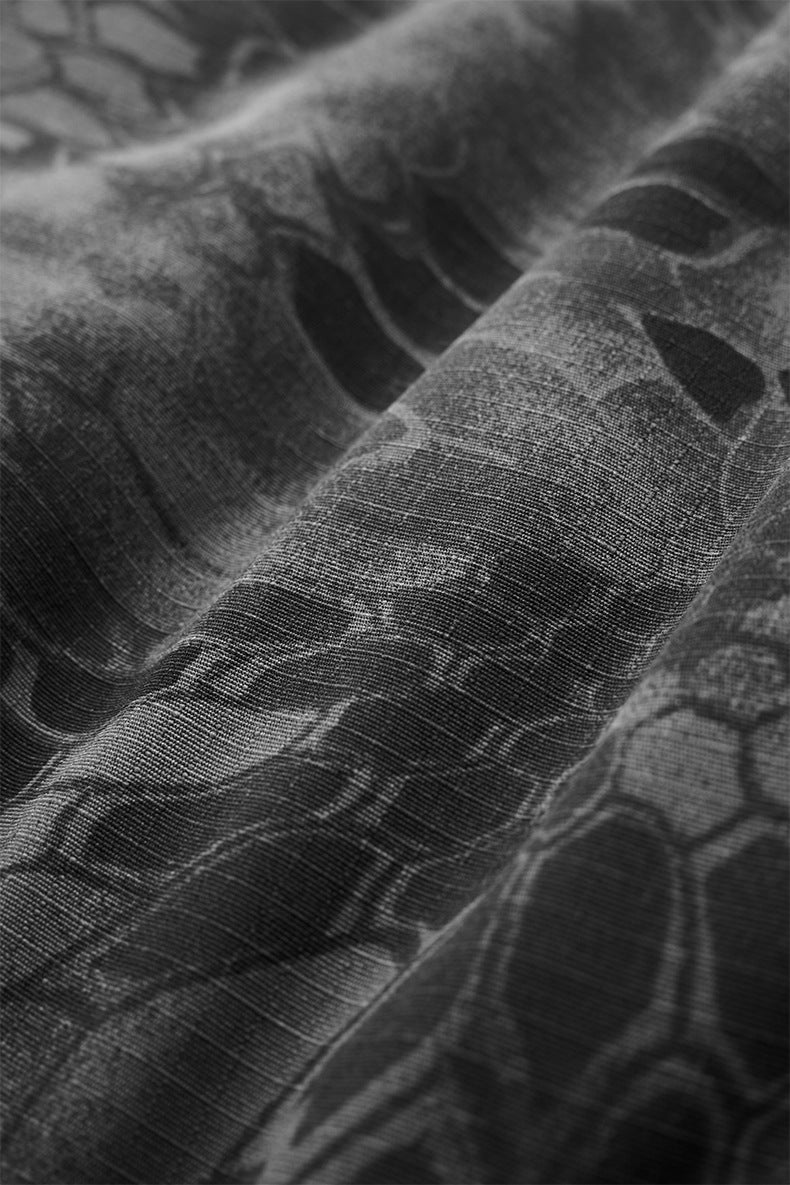 Tonal camo fabric texture close-up on dark gray bomber jacket