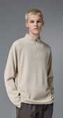 Man wearing khaki half zip long sleeve t shirt styled with brown pants