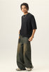 Three quarter side view of model wearing a black heavy cotton boxy t shirt with raw edge sleeves.