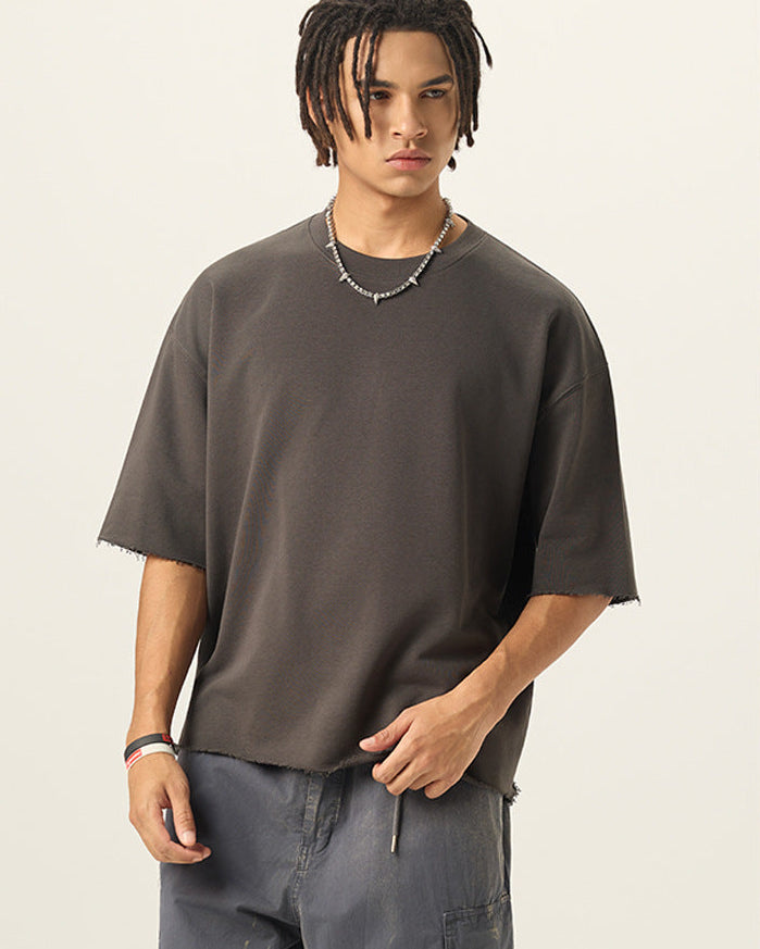 Half length front view of model wearing a charcoal grey 280G french terry raw edge short sleeve tee.