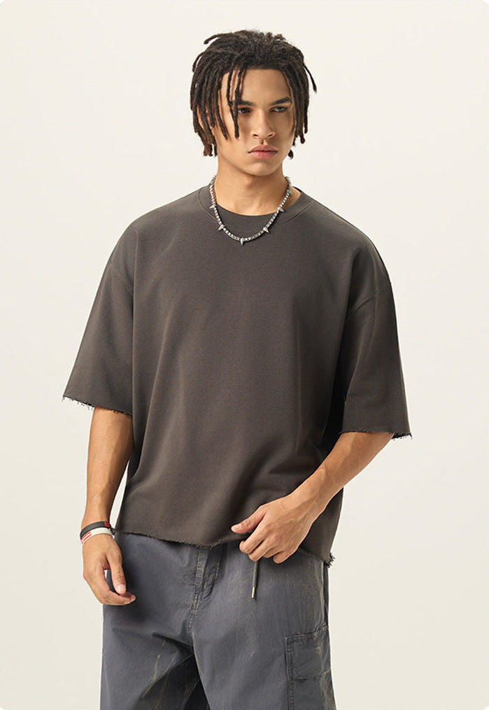 Half length front view of model wearing a charcoal grey 280G french terry raw edge short sleeve tee.