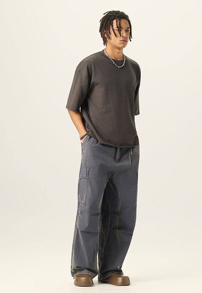 Side view of model wearing a vintage charcoal grey heavy cotton short sleeve t shirt with raw hems.