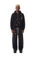 Full length view of model wearing a washed black boxy zip up hoodie with patches and matching sweatpants.