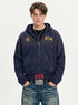Front view of model wearing a navy blue distressed zip up hoodie with paint splatter accents and hooded neck.