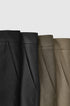 Close-up of mens dress pants fabric in black, khaki, and dark gray, brown colors. 