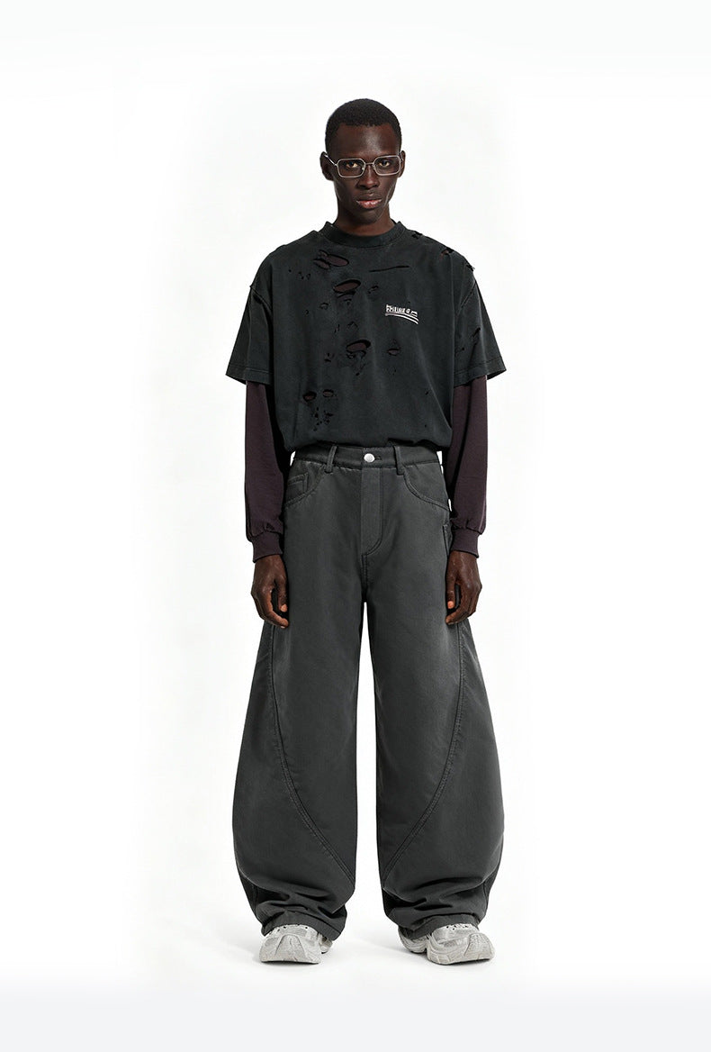 Front view of model wearing charcoal gray wide leg curved cargo pants paired with distressed long sleeve shirt.