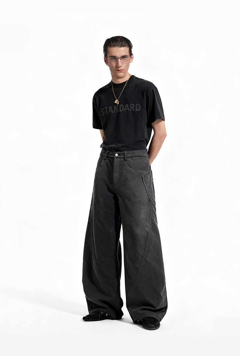 Full length view of model wearing charcoal gray fleece lined wide leg curved seam cargo pants with black tee.