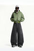 Model wearing charcoal gray fleece lined wide leg cargo pants paired with a green hooded bomber jacket and sneakers.