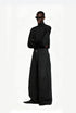 Model wearing washed black wide leg cargo trousers paired with a black graphic zip up hoodie and leather shoes.