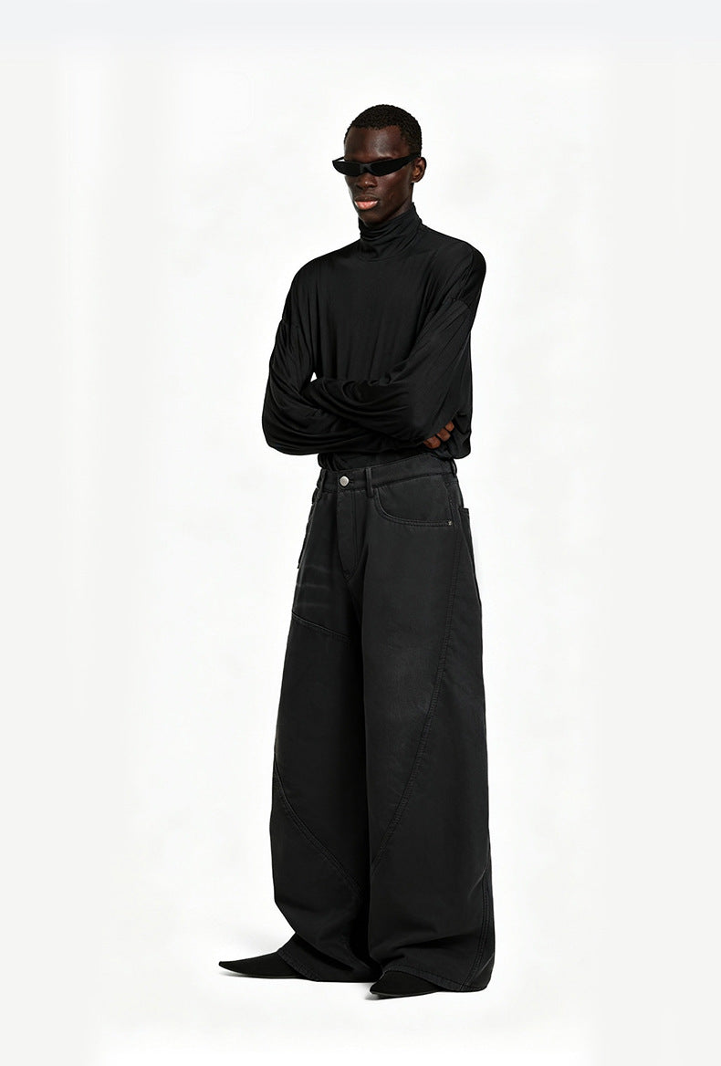Model wearing washed black wide leg cargo trousers paired with a black graphic zip up hoodie and leather shoes.