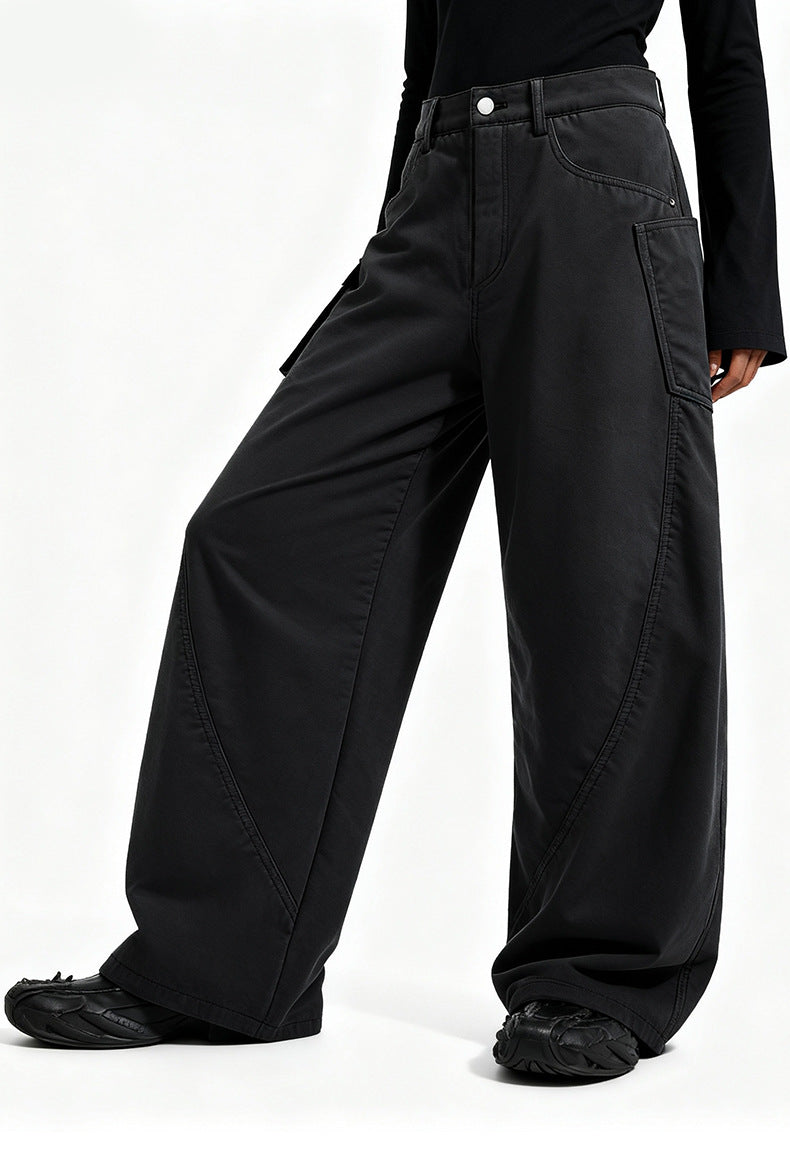 Side view of model wearing washed black fleece lined cargo pants featuring a wide-leg curved silhouette.