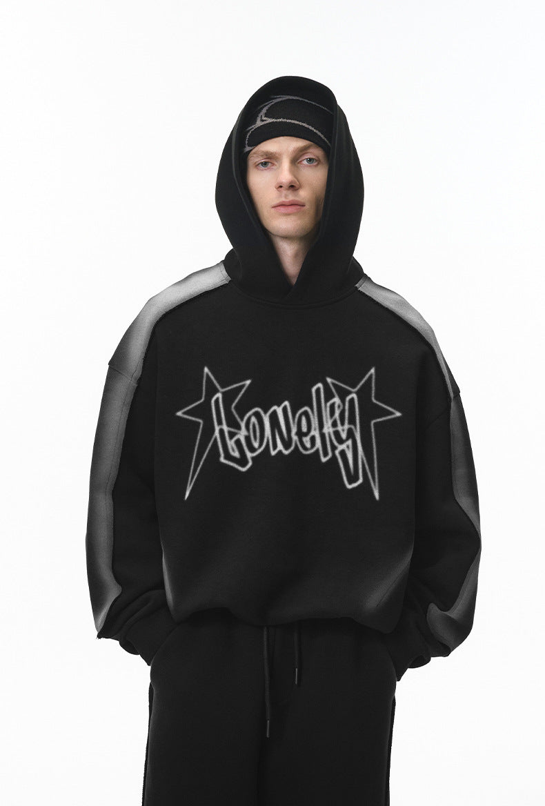 Male model in black graphic hoodie with hood up, straight on.