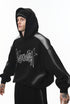 Three-quarter view of black graphic hoodie on model, relaxed stance.