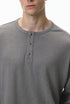 Close-up of a gray long-sleeve henley shirt worn by a person.