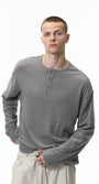 Man wearing a gray long-sleeve henley shirt on a white background