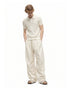 Men's ivory wide-leg drawstring pants styled with an open-knit polo and sandals.