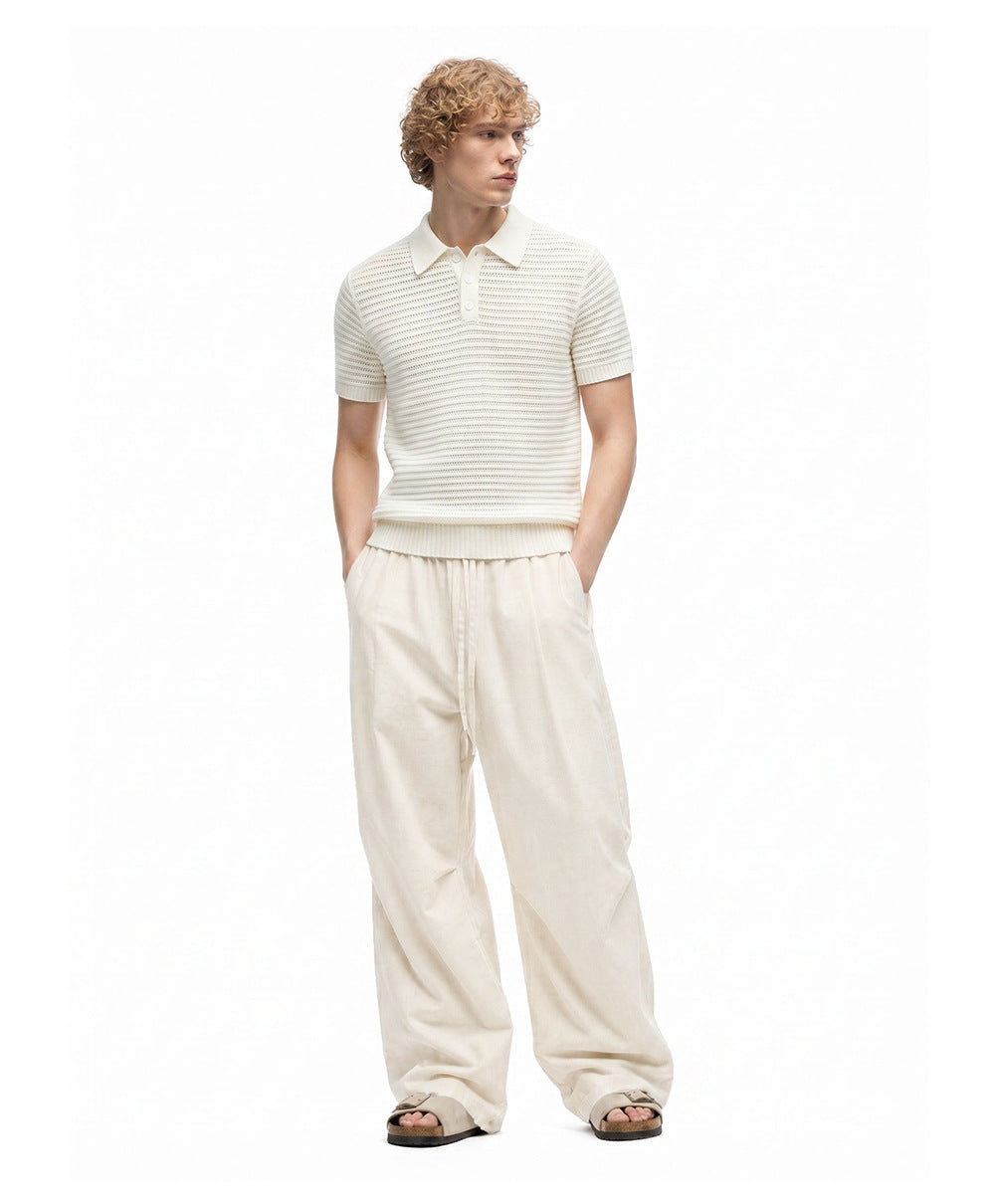 Front view of men's ivory relaxed pants showing full-length wide legs and drawstring waist.