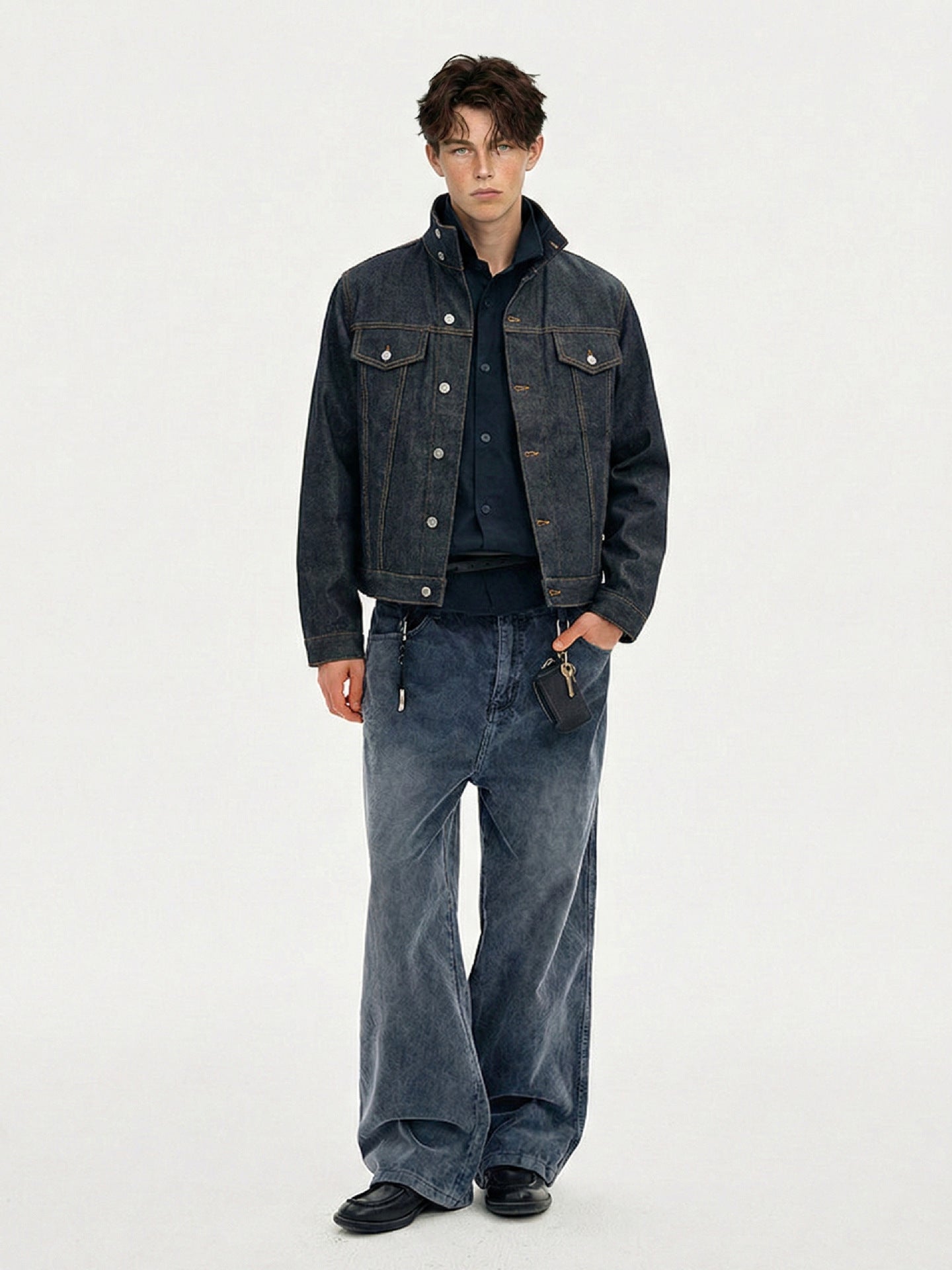 Full-length front view of dark indigo jacket worn open over a dark shirt and wide-leg jeans
