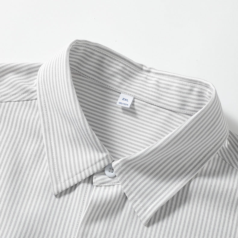 Close-up view of the spread collar and inner brand tag on a grey pinstripe dress shirt fabric.
