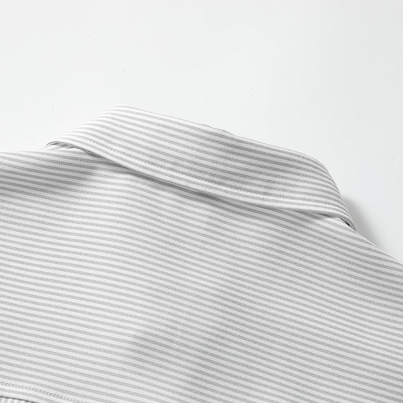 Close-up view of the chest patch pocket stitched on grey fine vertical pinstripe woven fabric.