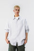 Front shot of model wearing a grey and white pinstripe long sleeve button up shirt with dark pants.