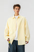 Front view of model wearing a yellow vertical pinstripe long sleeve casual shirt over a white tee.