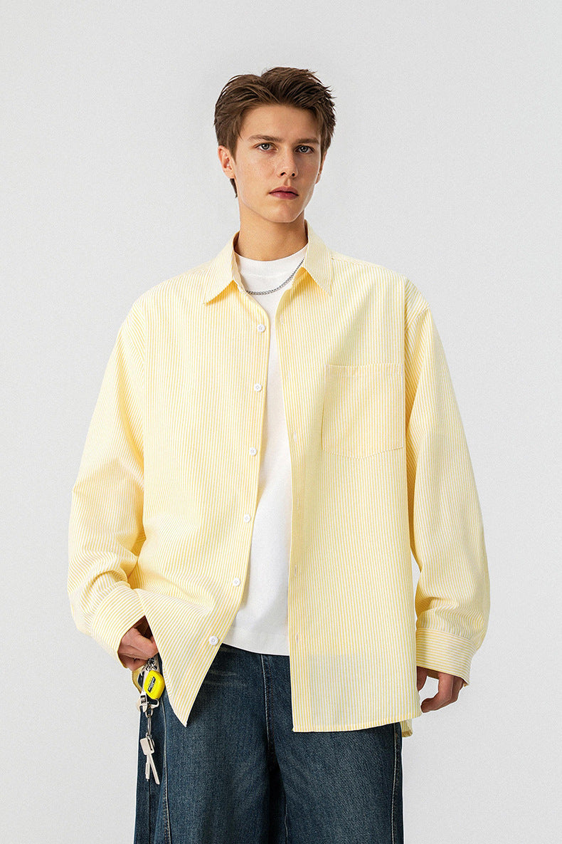 Front view of model wearing a yellow vertical pinstripe long sleeve casual shirt over a white tee.