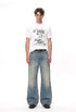 White graphic T-shirt styled with faded wide-leg jeans in a full-length front view.
