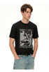 Three-quarter view of black punk tee paired with light-wash denim.