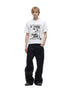 White open-knit graphic T-shirt styled with black wide-leg trousers.