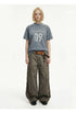 Men's vintage washed graphic T-shirt in blue gray styled with wide-leg cargo pants.