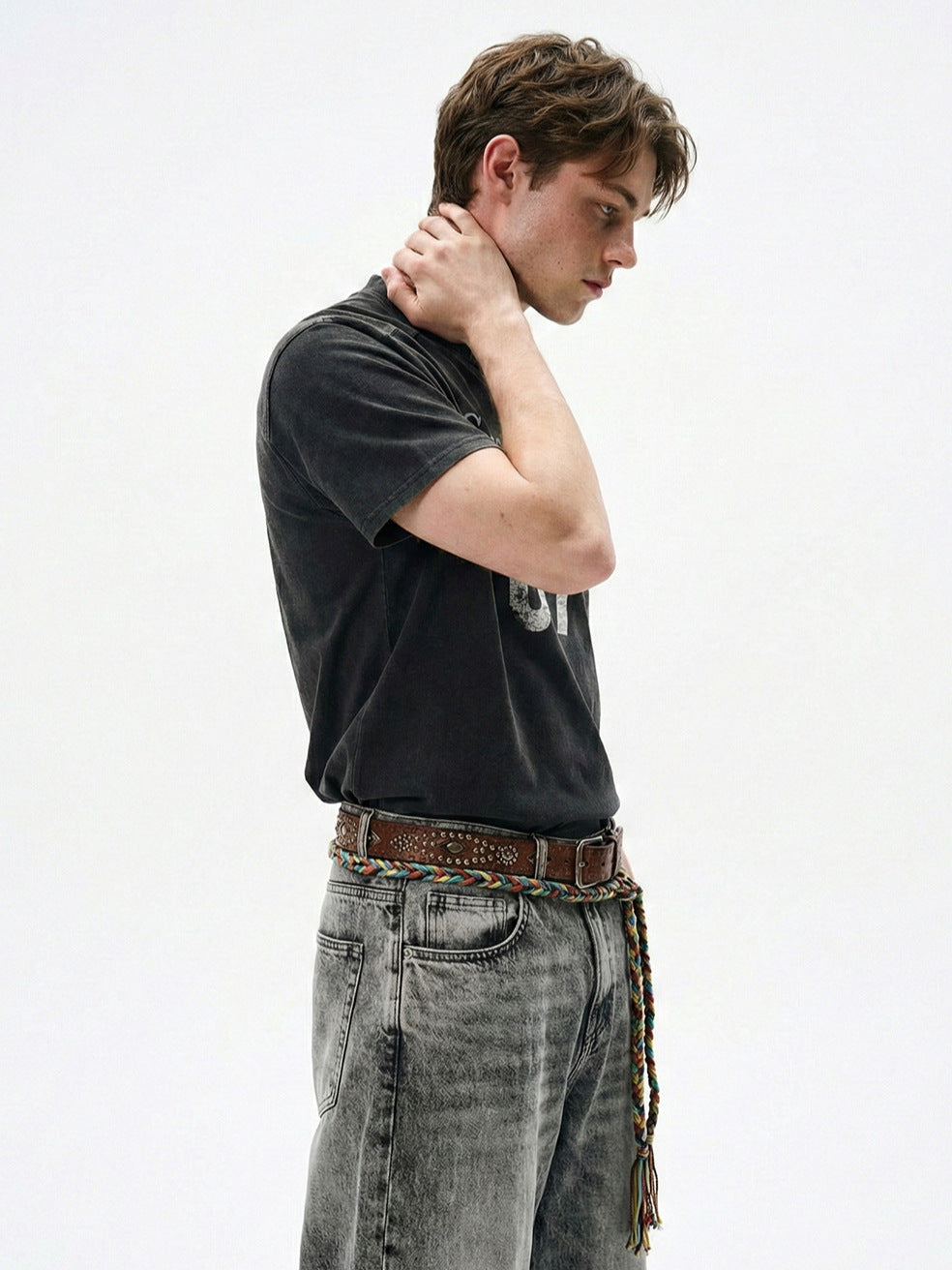 Side view of washed black boxy T-shirt showing straight shoulders and short sleeves.