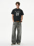 Full-length styling view of washed black 09 graphic tee with wide gray jeans.